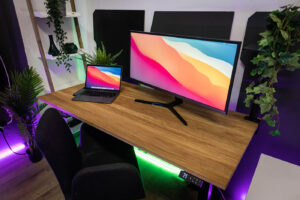 dębowe biurko z podnoszeniem elektrycznymi w zestawie z monitorem panoramicznym oraz laptopem